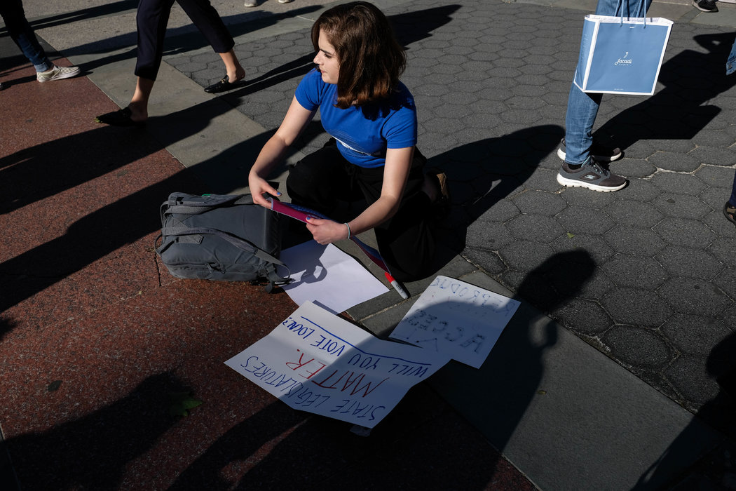 A young woman creating a poster for the #StopTheBans rally in New York. The protest called attention to legislation restricting access to abortion.